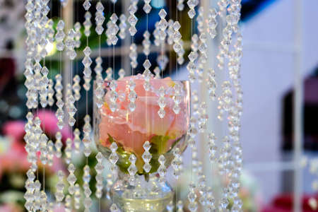 Quartz crystals hanging Surrounded by pink roses in the area.の写真素材
