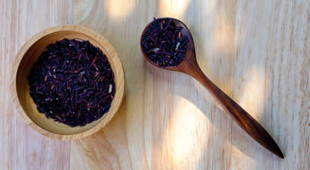 Organic Riceberry Rice on wood cup and spoon  (black jasmine rice)の写真素材