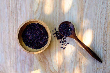 Organic Riceberry Rice on wood cup and spoon  (black jasmine rice)の写真素材