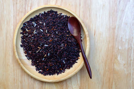 Organic Riceberry Rice on wood plate and spoon  (black jasmine rice)の写真素材