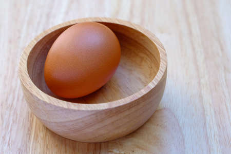 eggs in a wood cup on a wooden table.の写真素材