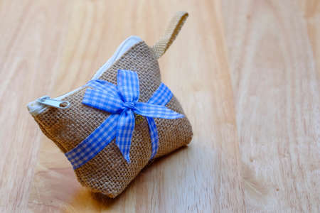 Bag hemp sack with blue ribbon on a wood backgroundの写真素材