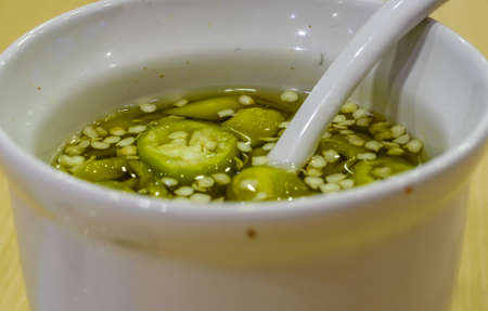 close up of a bowl of asian pickled green chiliesの写真素材