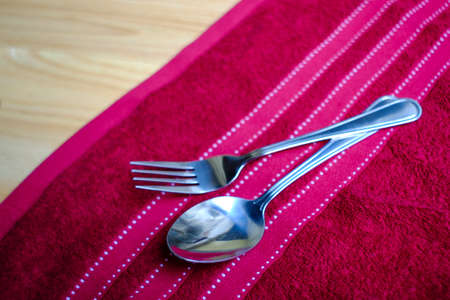 Vintage fork and spoon on red napkin and wood tableの写真素材
