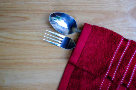 Vintage fork and spoon on red napkin and wood tableの写真素材