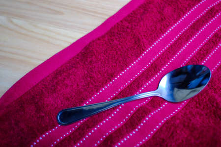 Vintage fork and spoon on red napkin and wood tableの写真素材