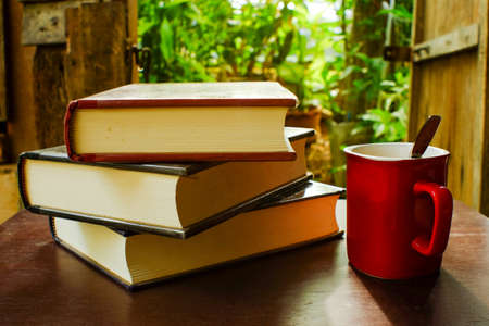Coffee and books on a wooden table brown.. (During the warm sunshine)の写真素材
