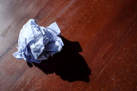 close up of a paper ball on wood table. (A reflection)