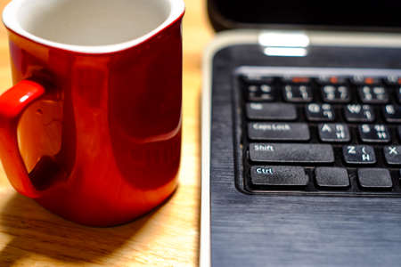 Desk table with laptop, coffee cup,  on wooden table. Workplace