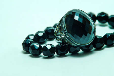 Sapphire ring with onyx bead necklace on white backgroundの写真素材