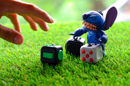 Songkhla, Thailand - July 19, 2017: Stitch playing Fidget Cube stress reliever, Fingers Toy (Pride)