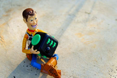 Songkhla, Thailand - June 20, 2017: Woody playing Fidget Cube stress reliever, Fingers Toy (Relax)のeditorial素材