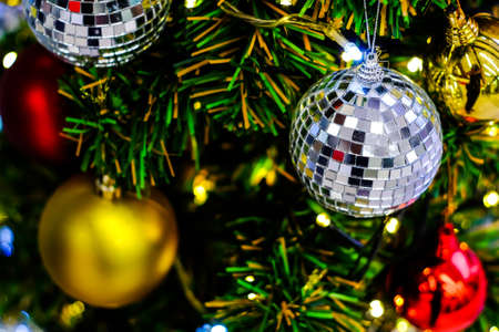 Merry Christmas and Happy New Year, Closeup of white bauble hanging from a decorated tree with...