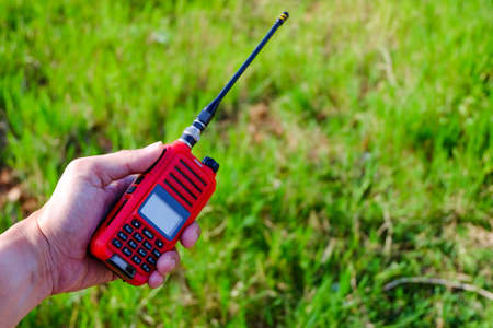 Portable radio transceiver in hand, nature on backgroundの写真素材