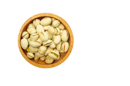 Pistachio nuts in wooden bowl on white background, isolatedの写真素材
