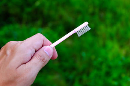 Thumbs Up with Pink Toothbrush on natureの写真素材