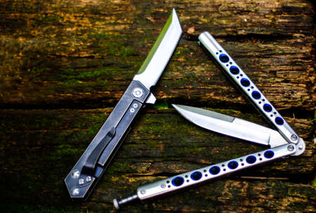 Butterfly knife (balisong) in a folded state against a Old wooden floors backgroundの写真素材