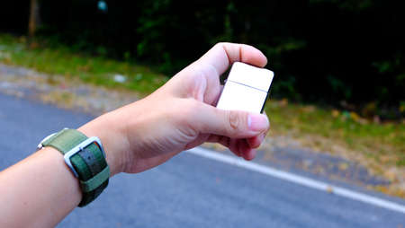 The male hands are setting fire up on nature background.の写真素材