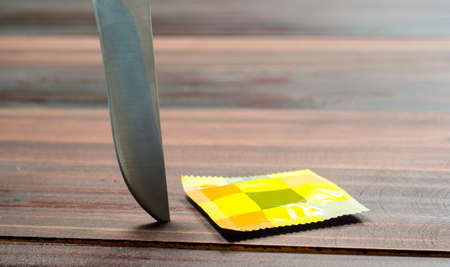 close up with condom and knife on wooden table Valentine concept