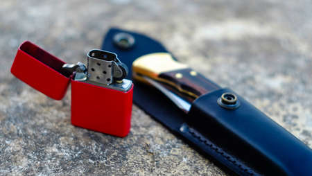 knife and red lighter on a wooden backgroundの写真素材