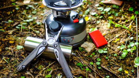 Ground coffee and moka pot coffee maker over rustic nature background, camping