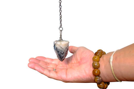 Foretelling the future with crystal pendulum. holding and using quartz crystal pendulum and using...