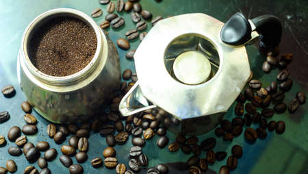 Ground coffee and moka pot coffee maker over rustic glass background. Coffee In A Moka Pot