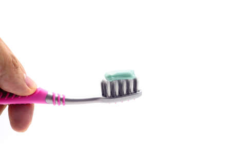 toothbrushes in hand isolated on the white background. amount of toothpaste is applied to the of...