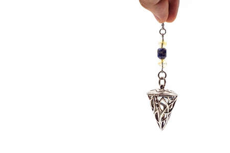 Close up of hand holding and using amethyst crystal pendulum on silver chain fortune telling...