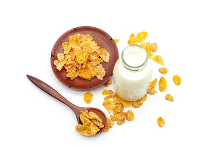 top view cereal in wood spoon with milk in glass bottles isolated on white background.