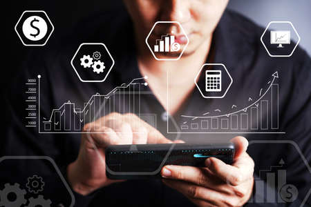businessman hand working on smartphone with digital layer business strategy and social media diagram on wooden desk. new technology bigdata and business process strategy.の写真素材