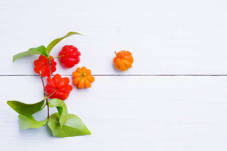 Acerola Cherry with green leaf on white table background. copy space.