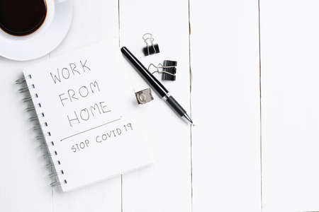 White office wooden desk table with blank notebook, pen and diary work from home note. Top view, flat lay.の写真素材