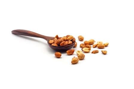 Roasted peanuts in a wooden spoon, isolated on a white backgroundの写真素材