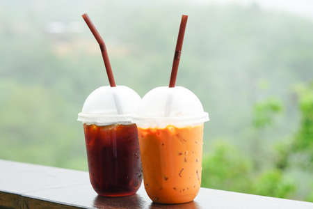 Fresh Homemade iced Tea or ice black tea on nature background. Delicious iced tea in glass on wooden...