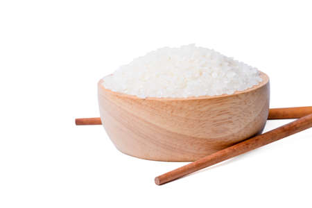 Isolated raw rice . Raw rice japanese in wooden bowl with  chopsticks white on background. asian white rice or uncooked.の写真素材