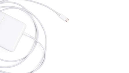 Isolated Adapter Charger. Top view Charger cord and plug for gadget on white. USB cable connector...