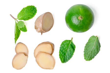Isolated sliced ginger and lime. Flat lay Fresh sliced ginger rhizome with lime and green mint...