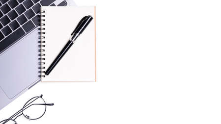Flat lay blank notebook with pen are on top of white office desk table with laptop computer and...