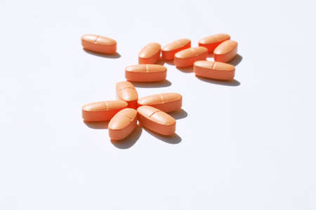 oblong pink pills scattered on the tableの写真素材