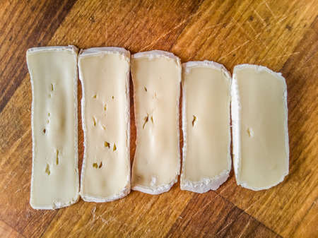 Sliced camembert on a wooden board.の写真素材