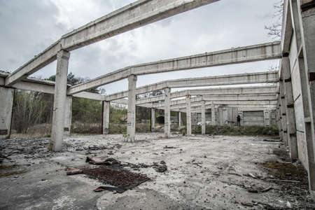 Kyiv, Ukraine - 25 of April 2020: Abandoned unfinished concrete roofless hangar in cloudy day.のeditorial素材