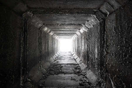 Empty square concrete tunnel with light in the end. Dried culvert.の写真素材