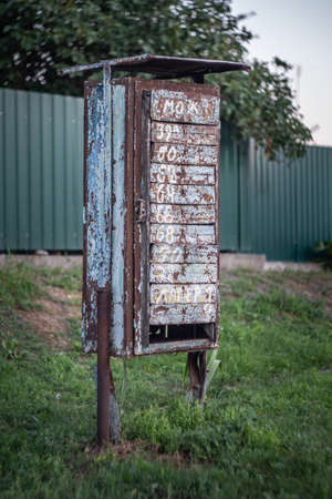 Old rusty abandoned metal mailbox in the countryside.の写真素材