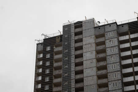 Facade of a multi-storey panel house in the process of wall decoration.