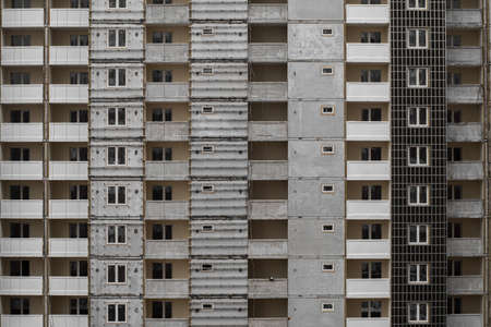 Textured facade of a multi-storey panel house in the process of wall decoration.