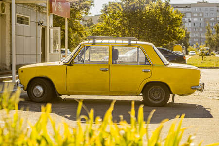 Yellow Zhiguli car on the street on a sunny day. Old vintage soviet car. Kaniv, Cherkasy Oblast, Ukraine - September 2021.のeditorial素材