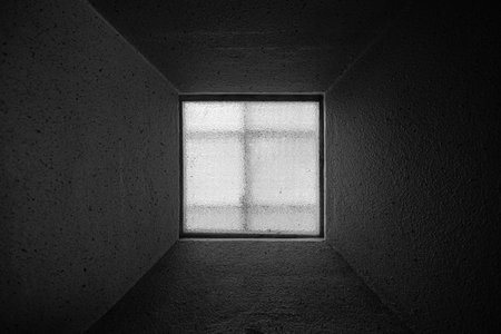 Abstract square window in dark room with a very long window sill.の写真素材