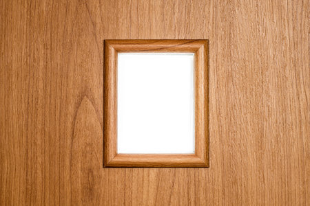 Textured small decorative window in a frame on a wooden wall with a white background behind.