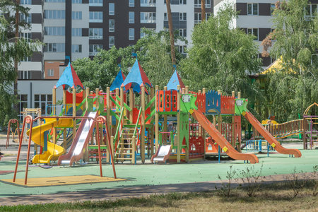 Multicolored outdoor playground in residential district. Irpin, Kyiv oblast, Ukraine - 11 Jun. 2022.のeditorial素材